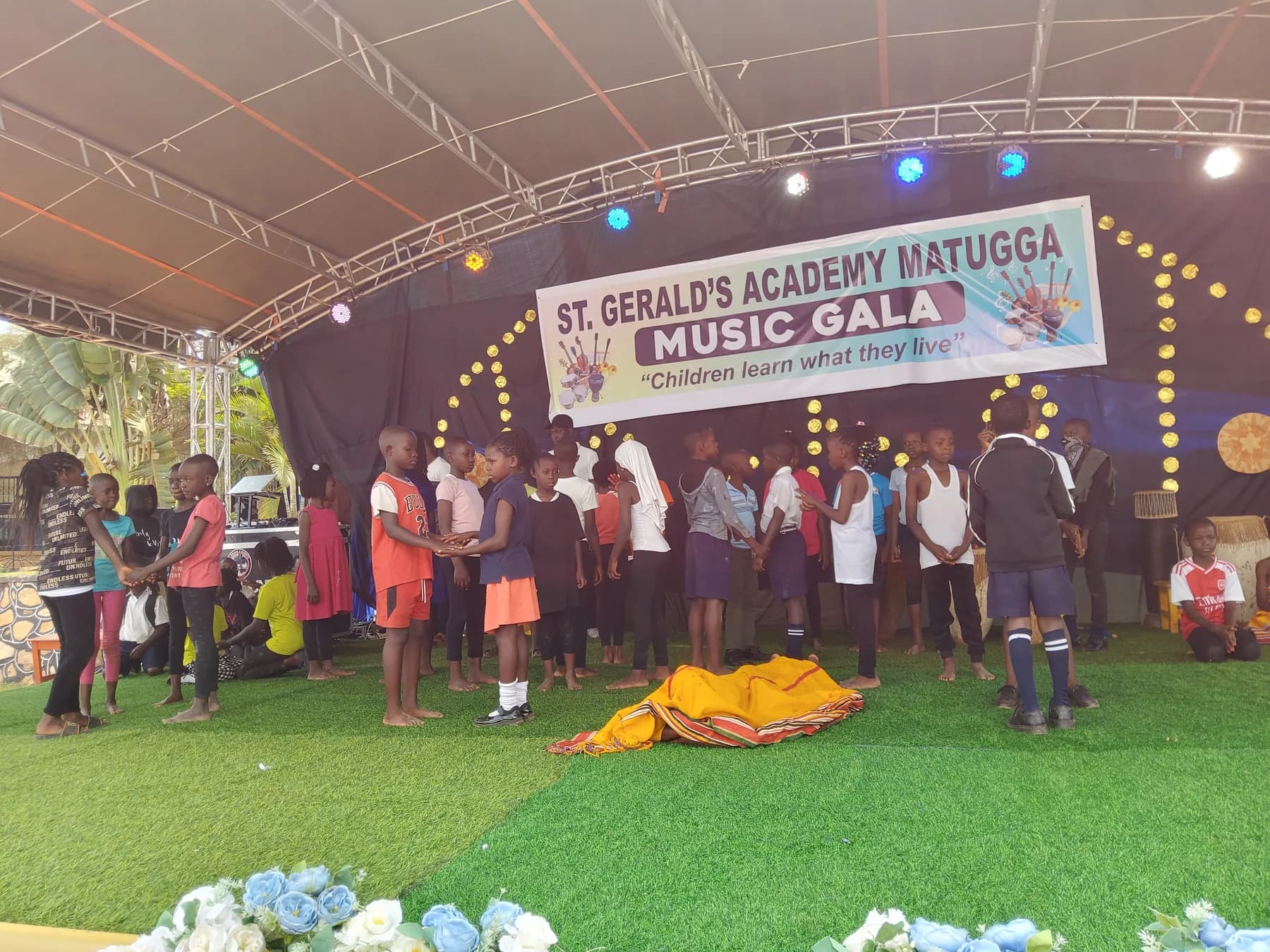Learners in contemporary clothing arranged in pairs for a stage scene